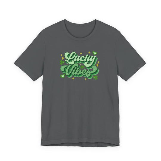 Charcoal crew-neck “Good Day Lucky Day Tee” with glittery green “Lucky Vibes” graphic, featuring shamrocks and hearts, ideal for St. Patrick’s Day celebrations.