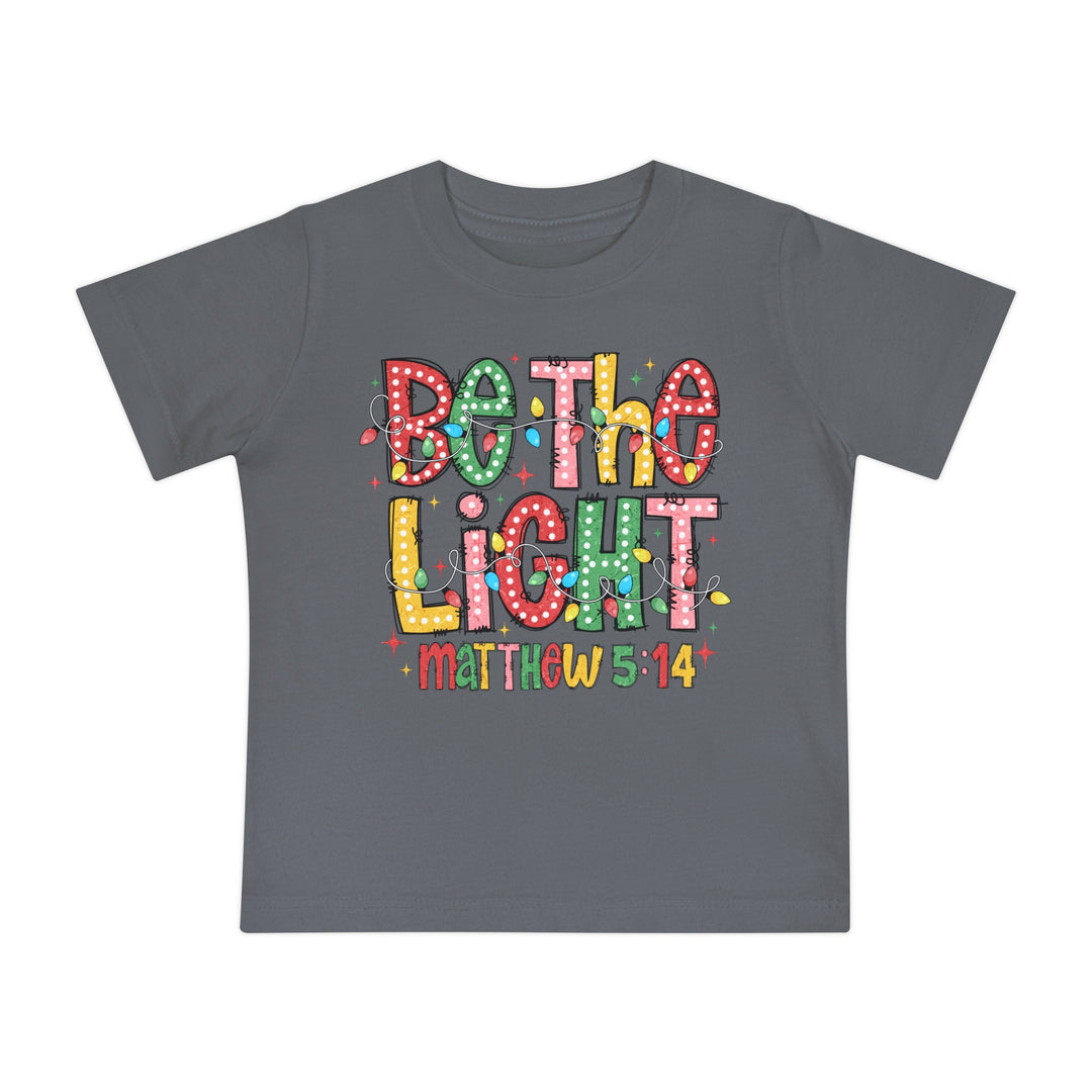 Children's slate-gray Be the Light T-shirt with colorful lettering and Christmas lights, featuring Matthew 5:14. Soft, shrink-resistant, 100% cotton for comfort and durability.