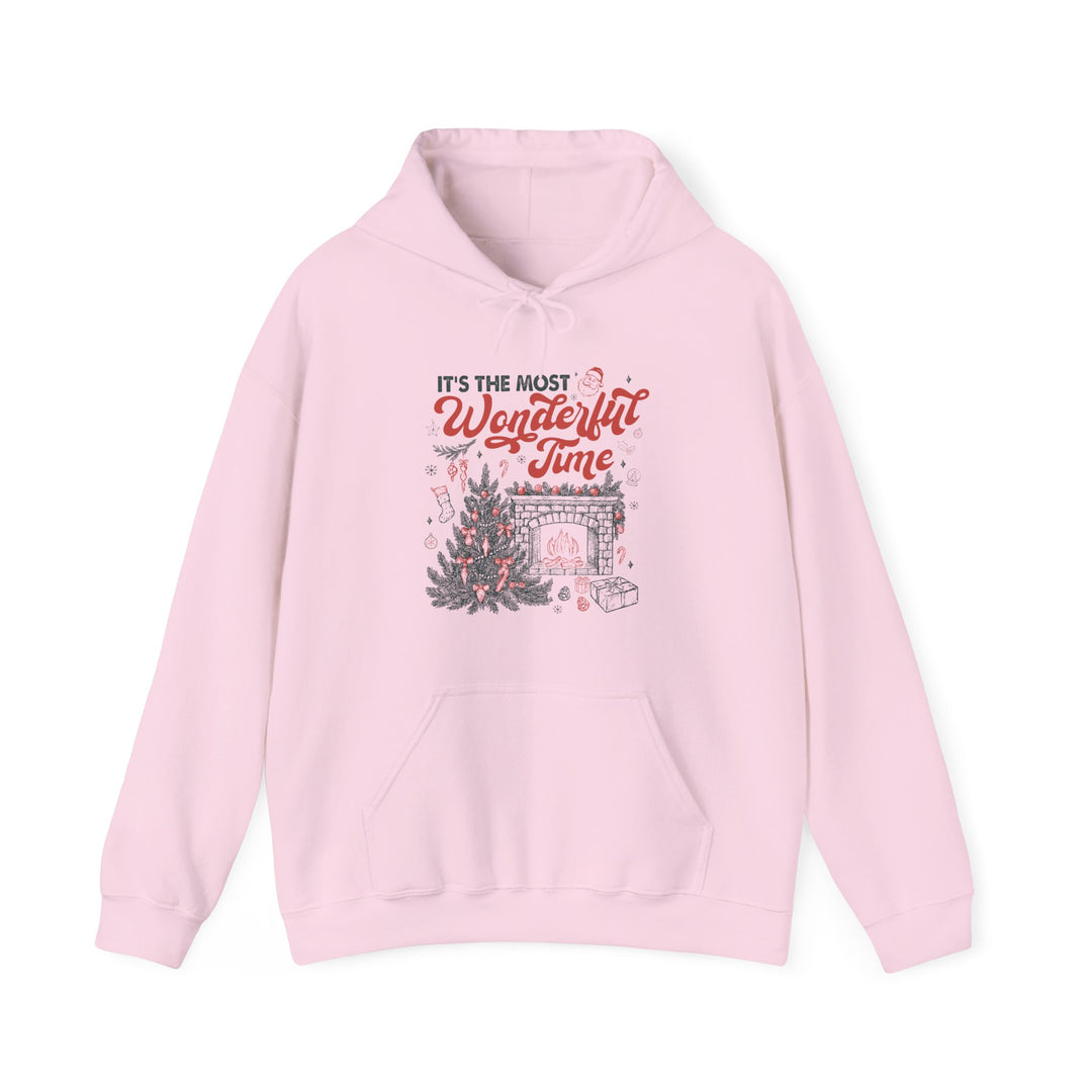 Pastel-pink Most Wonderful Time of the Year hoodie with holiday-themed graphic, featuring a Christmas scene on the chest and a kangaroo pocket.