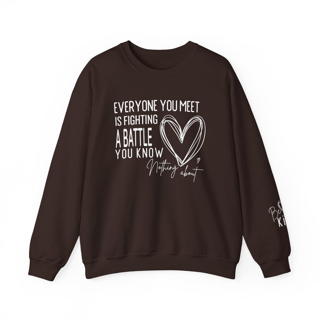 Dark-brown crewneck sweatshirt with motivational text Everyone you meet is fighting a battle you know nothing about and a heart sketch, featuring Be Kind on the sleeve.