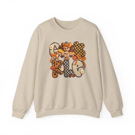 Light-beige crewneck sweatshirt with GOBBLE in crocheted-style patches, featuring autumn-themed designs and a cartoon turkey for a festive, Thanksgiving-inspired look.