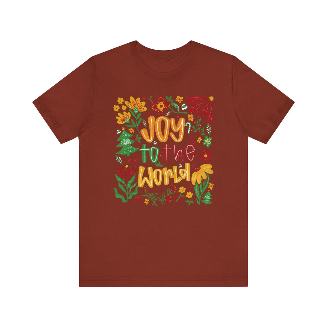 Joy to the World Tee features a festive graphic with colorful lettering and holiday doodles on a soft, brick-red crew-neck t-shirt.