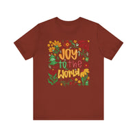 Joy to the World Tee features a festive graphic with colorful lettering and holiday doodles on a soft, brick-red crew-neck t-shirt.