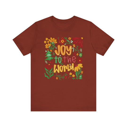 Joy to the World Tee features a festive graphic with colorful lettering and holiday doodles on a soft, brick-red crew-neck t-shirt.