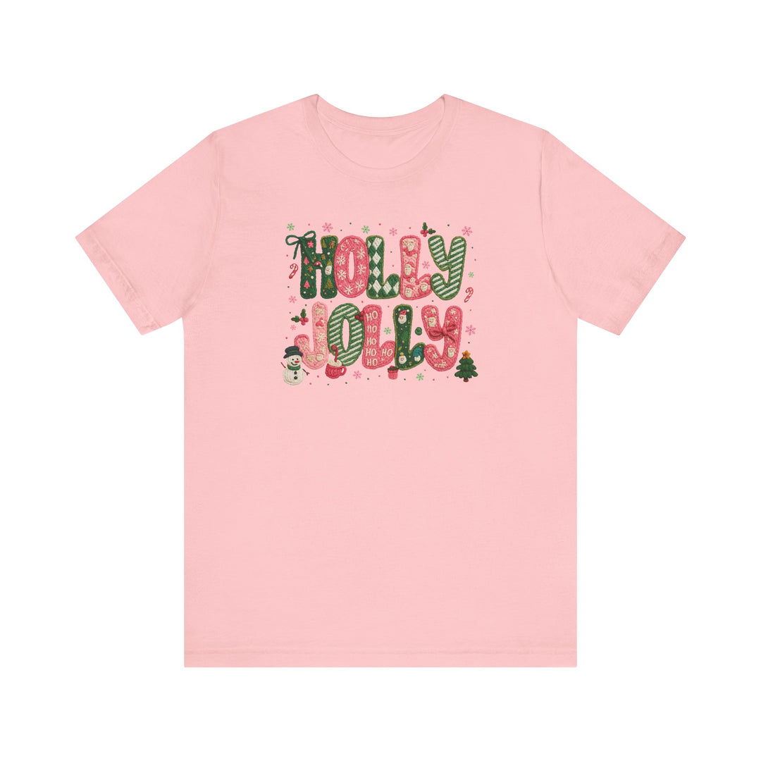 Holly Jolly Tee: Pale-pink short-sleeve shirt featuring festive HOLLY JOLLY graphic with candy-cane letters, snowman, mittens, and Christmas motifs. Classic unisex fit.
