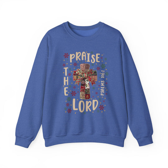 Praise the Lord Crew: A royal-blue sweatshirt featuring a quilt-style cross design with festive motifs and PRAISE THE LORD text, ideal for cozy, faith-inspired wear.