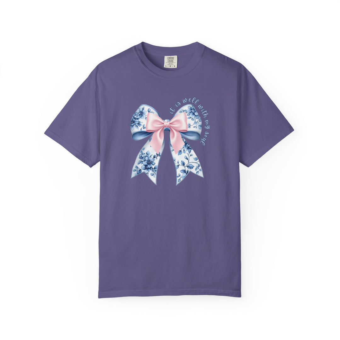 It is Well With My Soul Tee featuring a decorative bow with floral patterns and inspiring text on a lavender T-shirt, blending comfort with unique style.