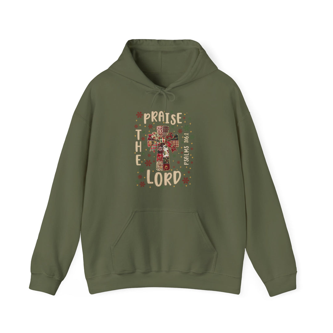 Praise the Lord Hoodie featuring a cross graphic with fabric patches, snowflakes, and stars, plus “Psalms 106:1” text on an olive-green pullover with kangaroo pocket.