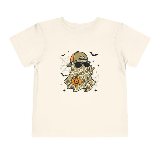 Candy Ghost Toddler Tee featuring a cartoon ghost in camouflage with sunglasses and baseball cap, surrounded by bats and spider-webs, holding a peace sign and jack-o-lantern.
