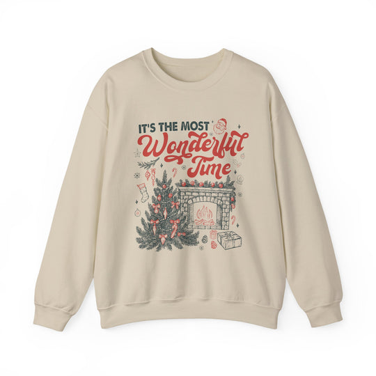 Cream-colored crewneck sweatshirt with festive It's the most Wonderful Time Christmas graphic featuring a tree, fireplace, and holiday motifs.