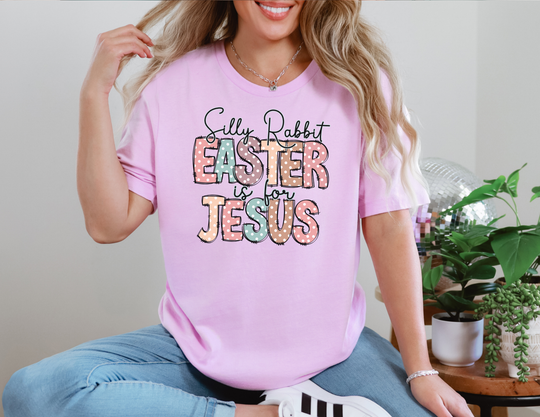 Woman seated wearing a Silly Rabbit Easter is for Jesus tee, featuring polka dots and text. The tee is a soft, unisex jersey short sleeve.