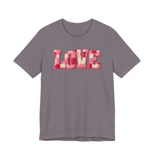 Love Tee with tufted LOVE text in pink hues on a muted grayish-purple short-sleeve shirt, showcasing a soft, classic fit from Faith Family Designs.