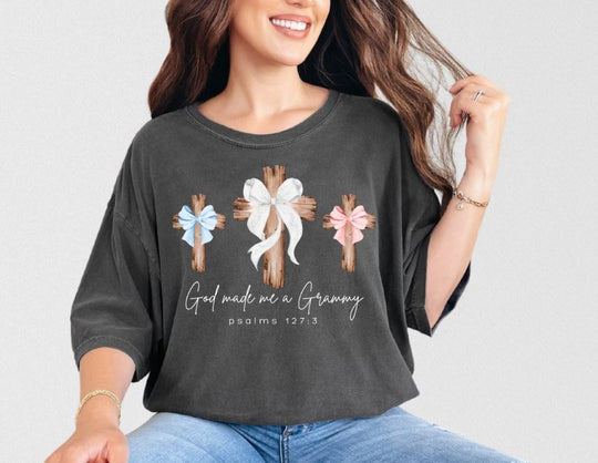 Woman wearing God Made Me a Grammy tee with three crosses, soft-wash charcoal design, relaxed fit, paired with light-wash jeans, from Faith Family Designs.