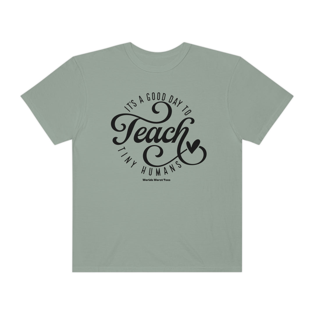 A Teach Tiny Humans Tee, unisex garment-dyed sweatshirt with a relaxed fit, 80% ring-spun cotton, 20% polyester, and medium-heavy fabric. Features rolled-forward shoulder and back neck patch.