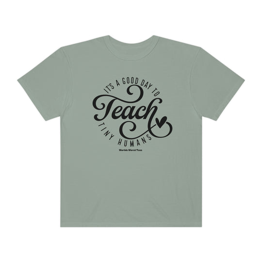 A Teach Tiny Humans Tee, unisex garment-dyed sweatshirt with a relaxed fit, 80% ring-spun cotton, 20% polyester, and medium-heavy fabric. Features rolled-forward shoulder and back neck patch.