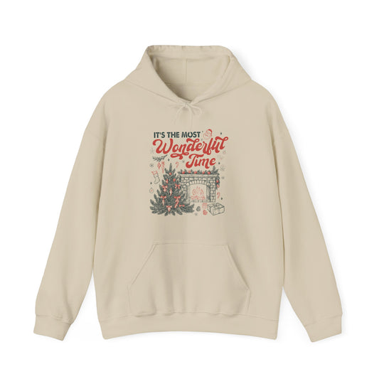 Light-beige Most Wonderful Time of the Year hoodie features festive vintage-style print with Christmas tree, fireplace, and gifts, offering cozy warmth and practical kangaroo pocket.