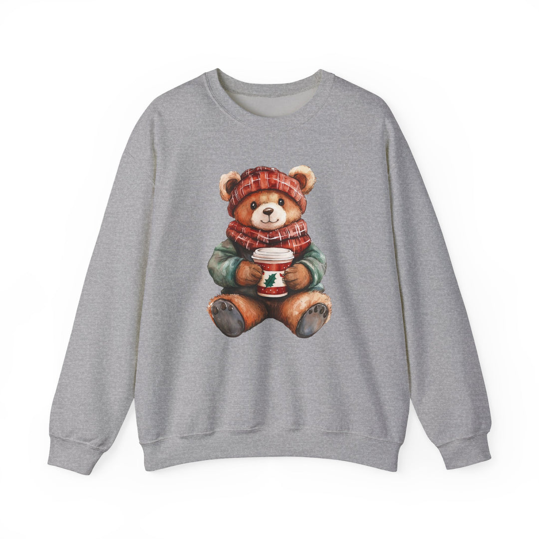 Light-gray crewneck sweatshirt featuring a winter-dressed teddy bear with a red hat and scarf, holding a holiday cup. Ideal for cozy wear, blend of cotton and polyester.