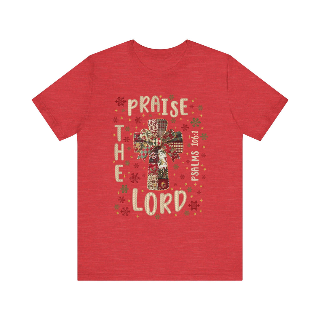 Praise the Lord Tee featuring a quilt-style cross with snowflakes, stars, and Psalms 106:1 reference. Comfortable fit with soft, durable cotton.