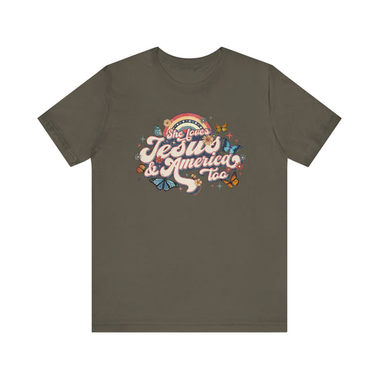 A grey t-shirt featuring a graphic design of butterflies and flowers, She Loves Jesus and America Tee. Unisex jersey tee with ribbed knit collars, 100% Airlume combed cotton, retail fit, tear away label.