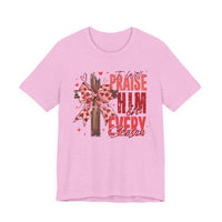 Light pink Praise in Every Season Heart Tee featuring a wooden cross with a pink bow and faith-inspired text, crafted from soft cotton for comfort.