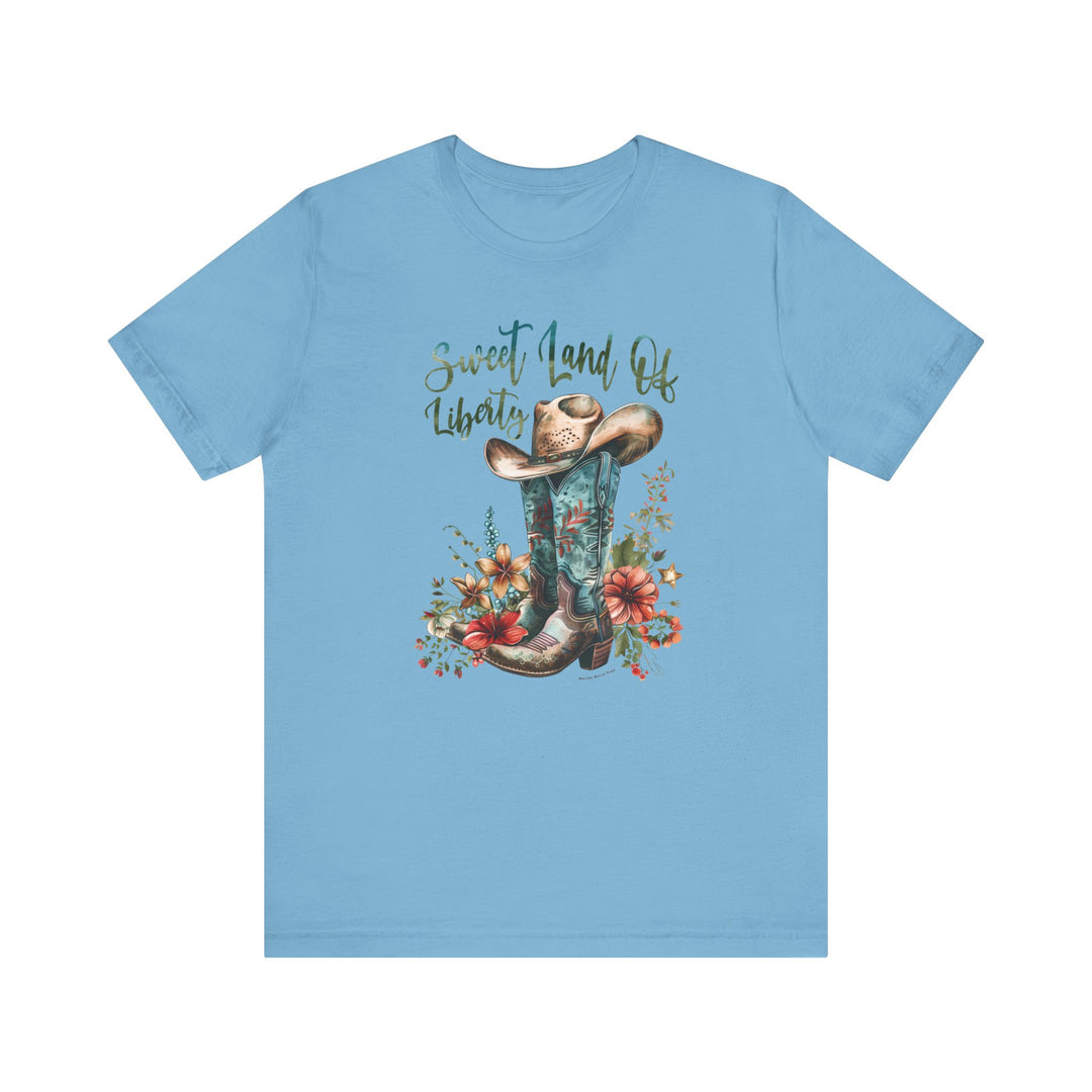 A classic Sweet Land of Liberty Tee, featuring a blue shirt with a cowboy hat and flowers design. Unisex jersey tee made of 100% Airlume combed cotton, with ribbed knit collars and taping on shoulders for a better fit.