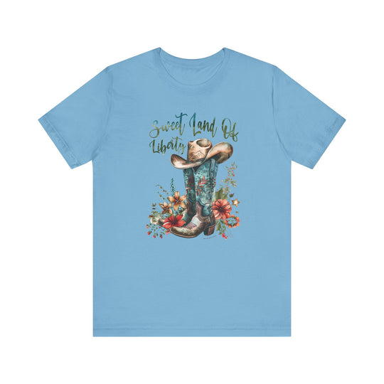 A classic Sweet Land of Liberty Tee, featuring a blue shirt with a cowboy hat and flowers design. Unisex jersey tee made of 100% Airlume combed cotton, with ribbed knit collars and taping on shoulders for a better fit.