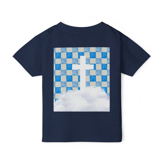 Heavy Cotton™ Toddler T-shirt's back showcases a navy-blue fabric with a graphic of a cross emerging from clouds under a checkerboard sky, emphasizing comfort and style.