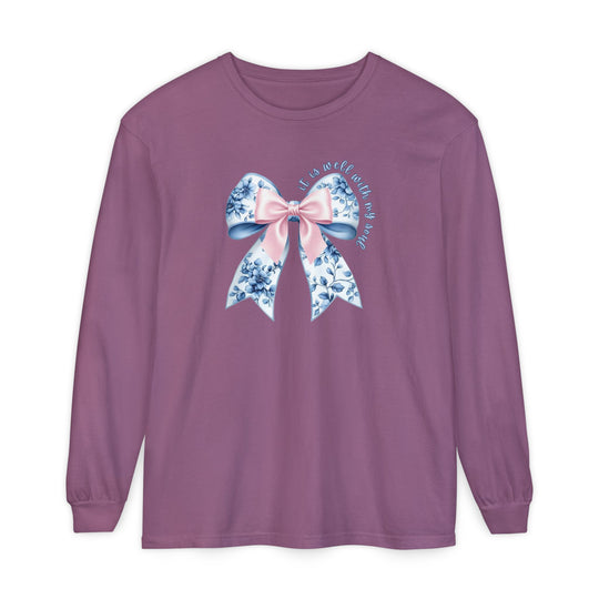 It is Well With My Soul Long Sleeve Tee featuring a floral bow and script on a muted purple background, offering comfort with 100% ring-spun cotton.