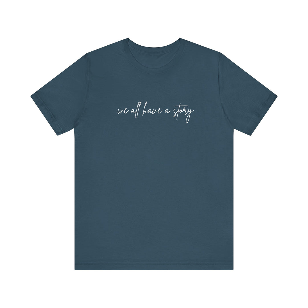 We all have a Story Tee: blue shirt with white text, classic unisex design, soft cotton, ribbed knit collar, and tapered shoulders for optimal fit.