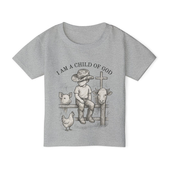 Toddler wearing I Am a Child of God tee, featuring a child with farm animals and a cross, showcasing rustic charm and spiritual message.