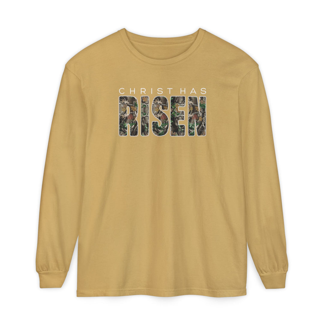 Mustard-gold long-sleeve tee with CHRIST HAS RISEN in white block letters and camouflage pattern, made of 100% ring-spun cotton for comfort.