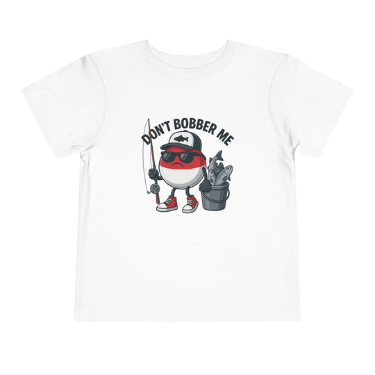 Don't Bobber Me Toddler Tee: Cartoon bobber character with sunglasses and cap, holding a fishing rod and fish bucket, printed on a white Bella Canvas toddler T-shirt.
