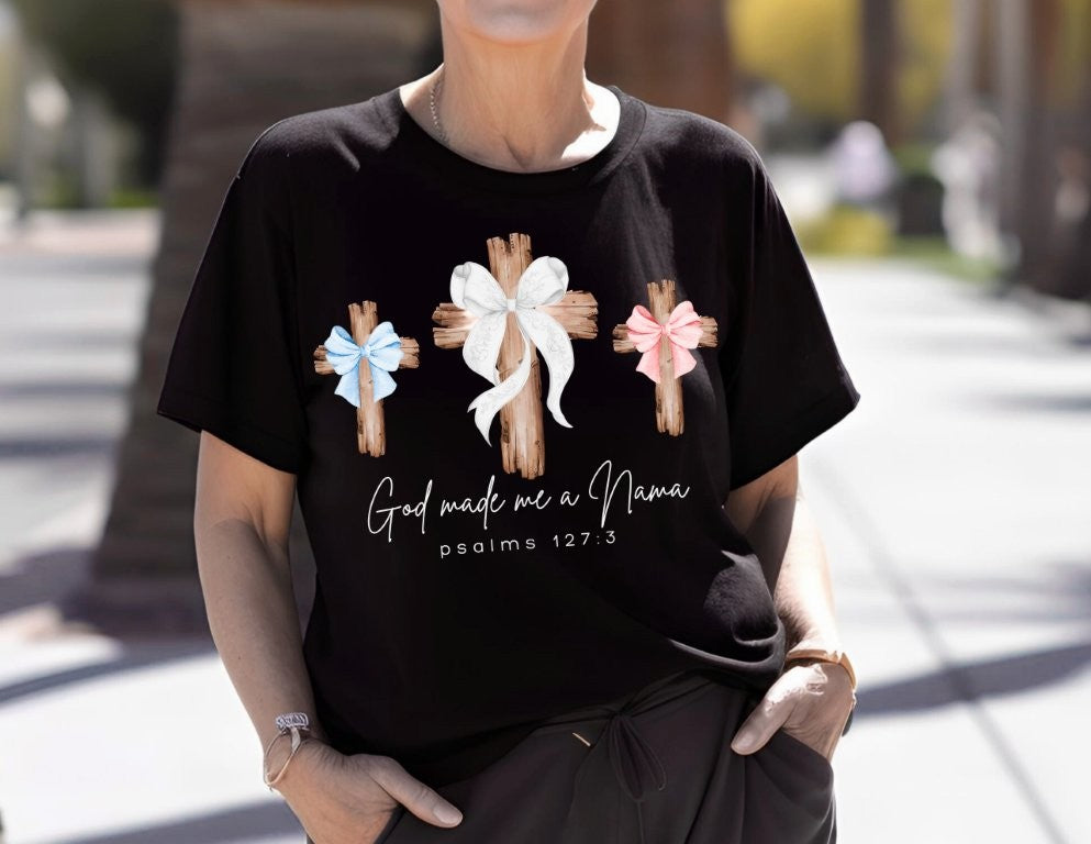 Person wearing God Made Me a Nana black T-shirt with three wooden crosses and text referencing Psalm 127:3, showcasing Faith Family Designs' unique graphic T-shirt style.