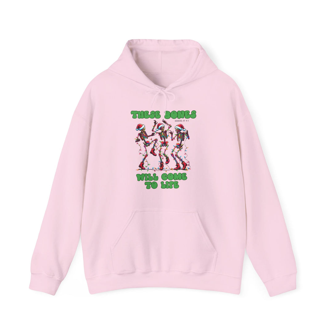 Light-pink hoodie featuring three dancing skeletons with Santa hats and Christmas lights, bold green text These Bones… Will Come To Life on chest.
