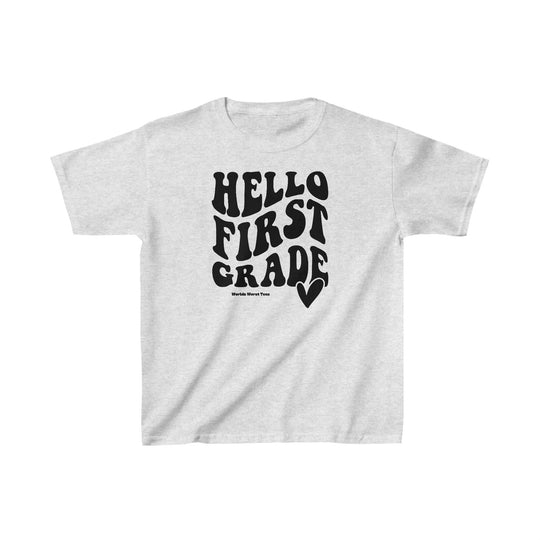 A 1st Grade Tee, white shirt with black text, perfect for kids. Made of 100% cotton, light fabric, classic fit, tear-away label, durable twill tape shoulders, and seamless sides. Sizes XS to XL available.