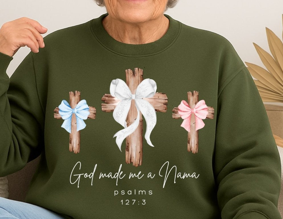 Older woman wearing olive-green God Made Me a Nana sweatshirt featuring three rustic crosses. Comfortable unisex design, 50/50 cotton-polyester blend, loose fit, medium-heavy fabric.