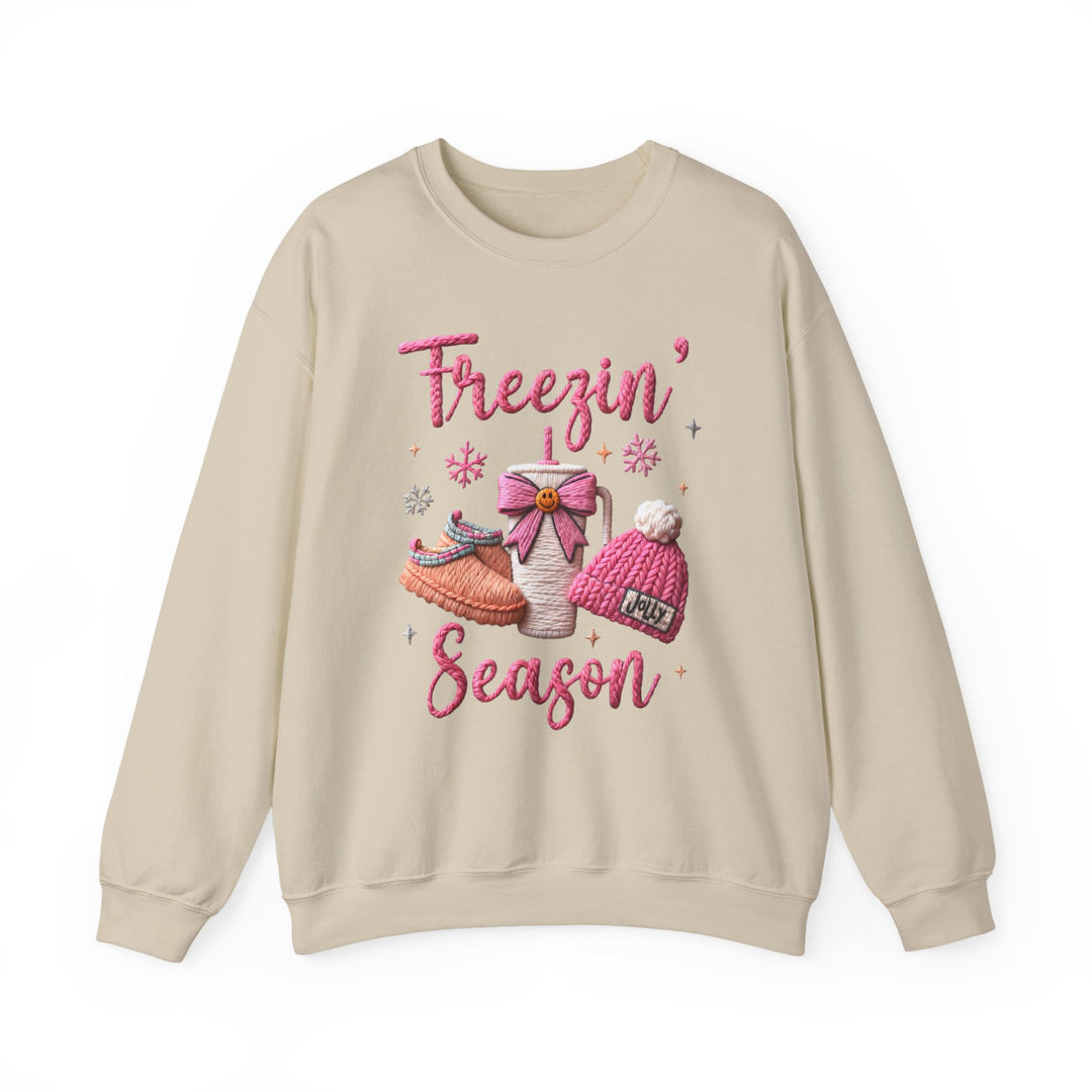 Freezin Season Crew sweatshirt with festive embroidery, featuring Freezin’ Season text, slippers, to-go mug, knit beanie, and snowflakes, offering cozy comfort and unique style.