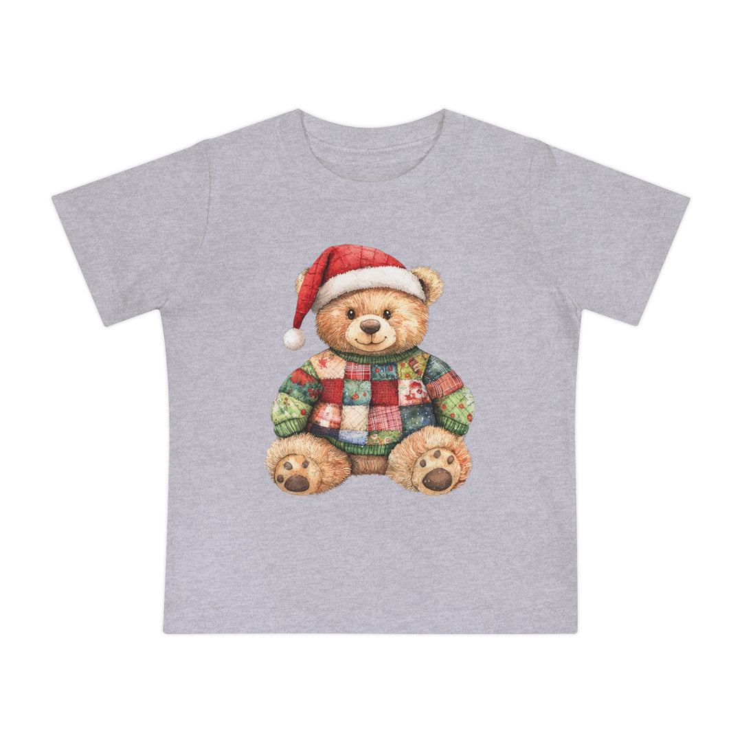 Christmas Bear Baby Tee featuring a teddy bear with a Santa hat and patchwork sweater, ideal for baby's first stylish steps. Made of soft, durable cotton.