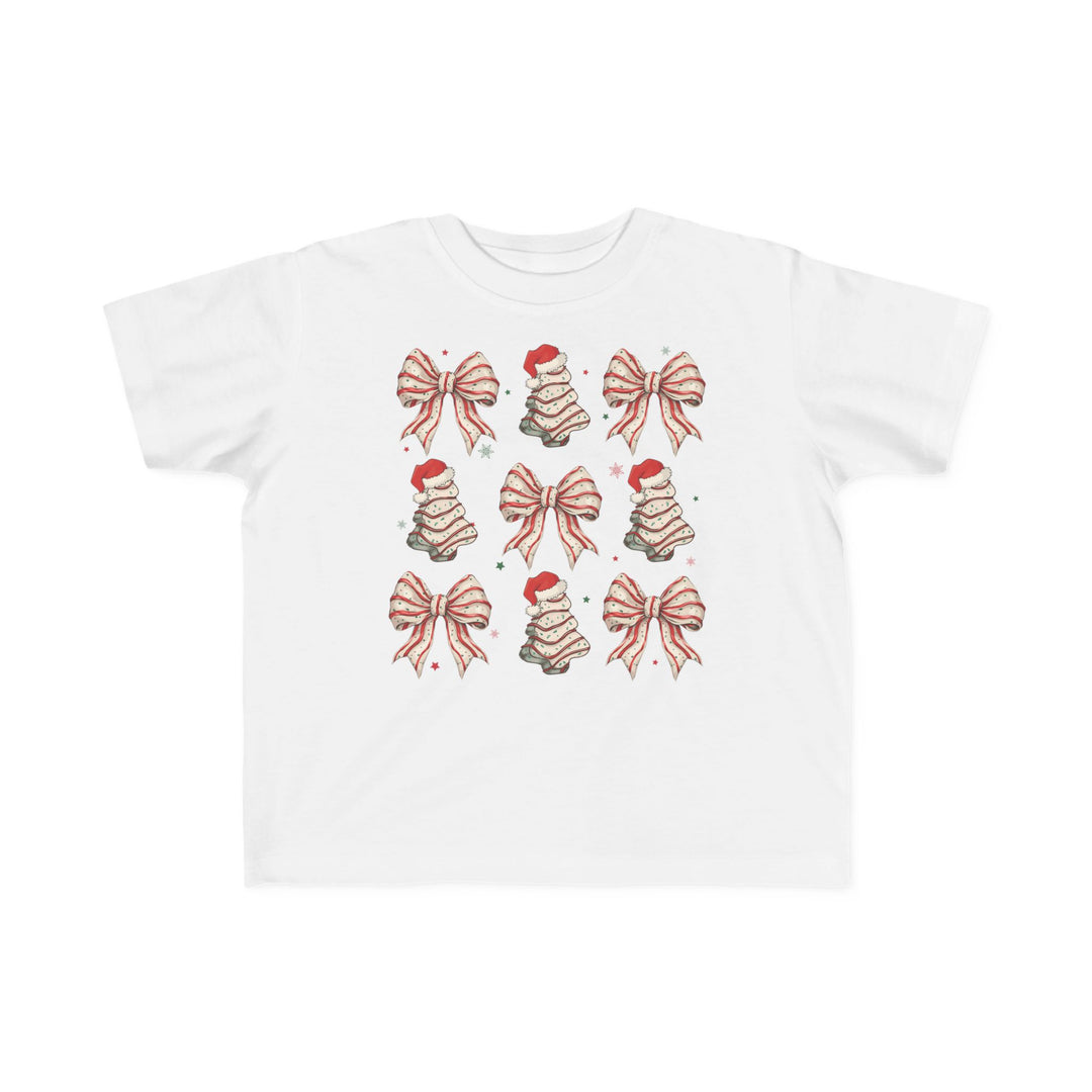 Cookies and Bows Toddler Tee features a grid of festive bows and Christmas trees with Santa hats, printed on a soft, durable cotton shirt for toddlers.