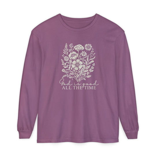 Muted purple long-sleeve tee with a white wildflower graphic and God is good ALL THE TIME text, offering softness and a relaxed fit.