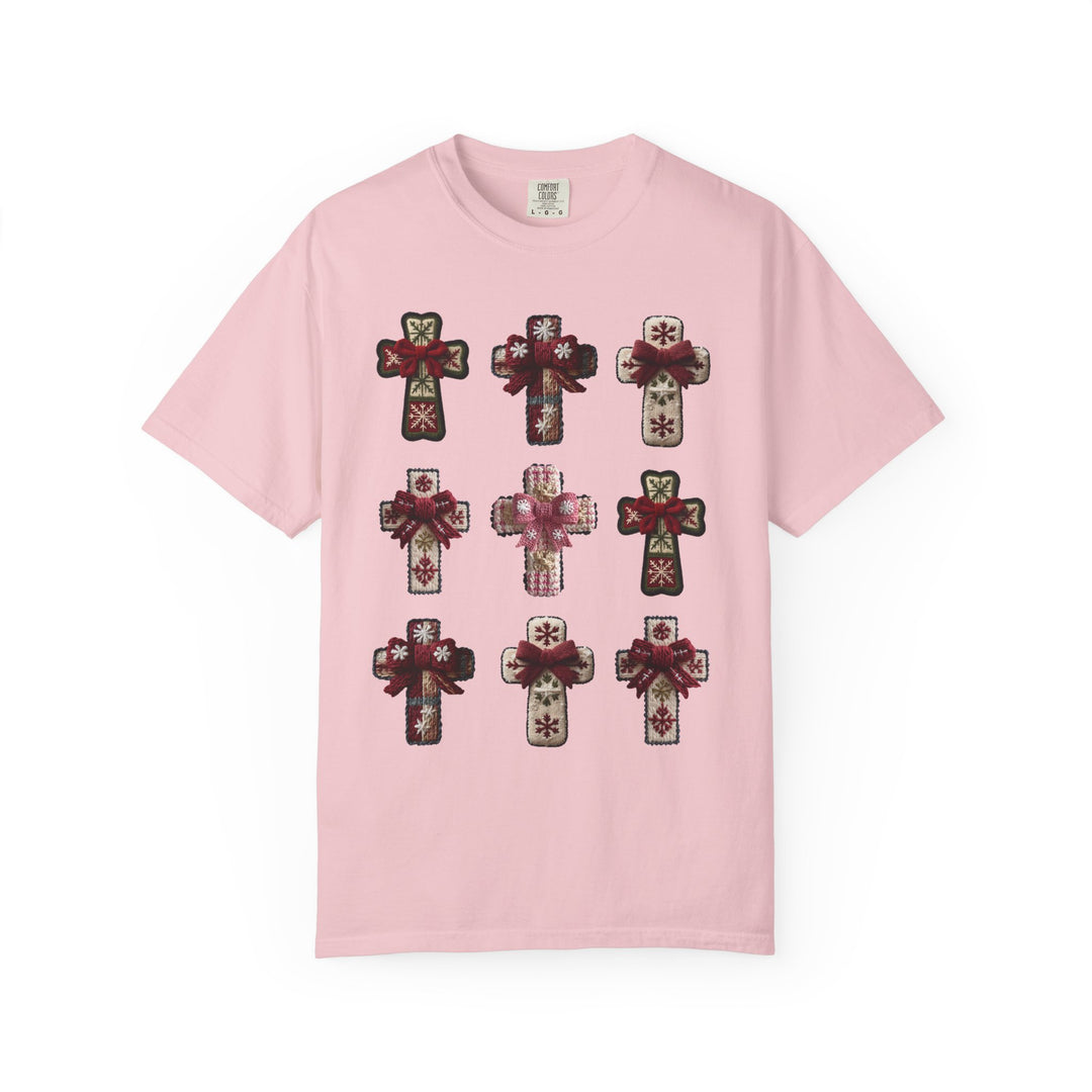 Crosses Tee: Light-pink cotton T-shirt featuring a 3×3 grid of decorative, knitted-look crosses with winter motifs and fabric bows, embodying stylish comfort.