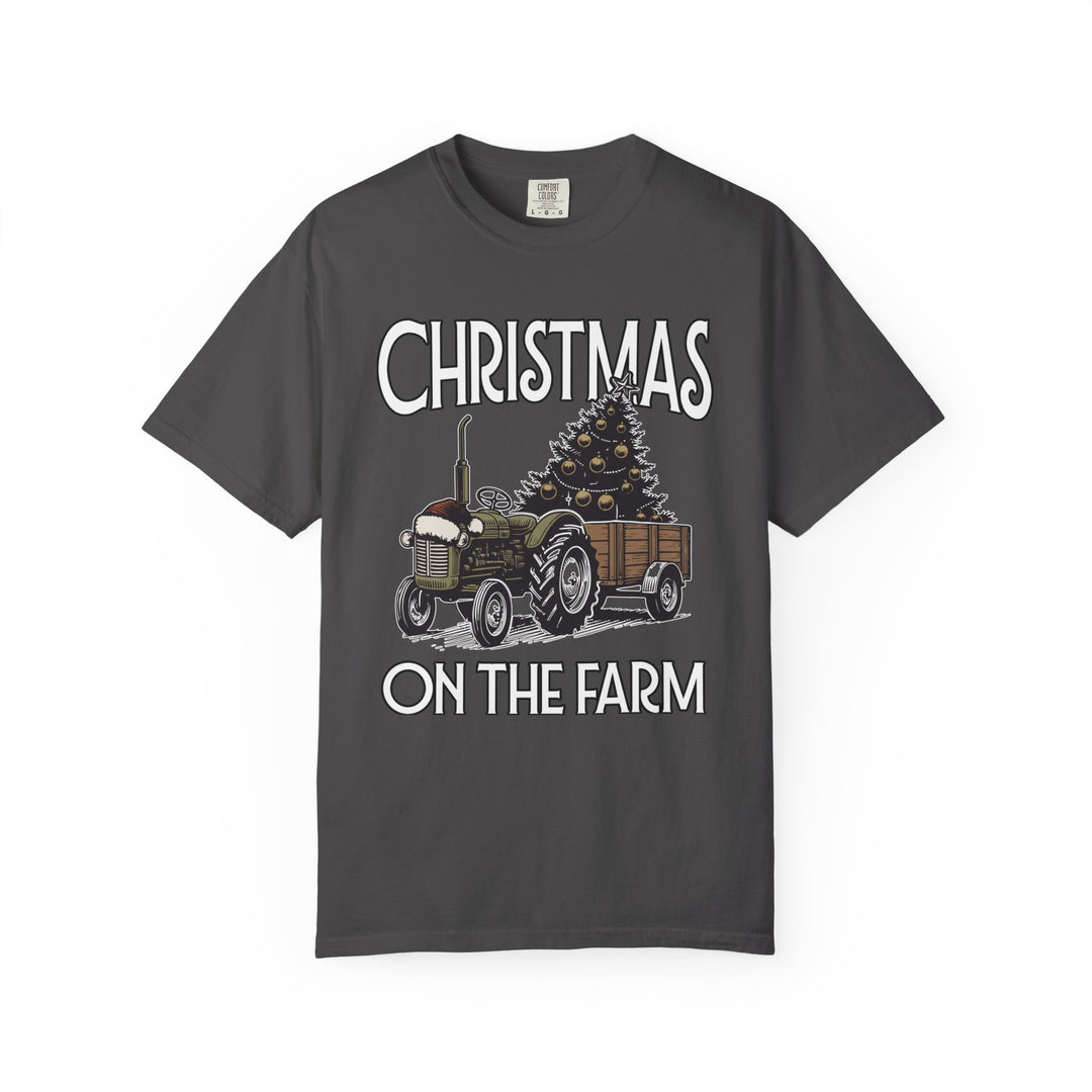 Christmas on the Farm Tee featuring a vintage tractor with Santa hat pulling a trailer with a decorated Christmas tree, bold festive lettering.