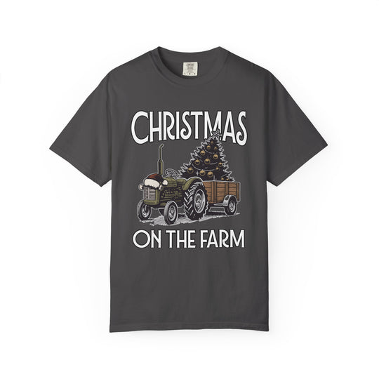 Christmas on the Farm Tee featuring a vintage tractor with Santa hat pulling a trailer with a decorated Christmas tree, bold festive lettering.