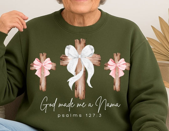 Older woman wearing a God Made Me a Nanna sweatshirt with wooden cross designs and ribbon accents, embodying comfort and faith from Faith Family Designs.