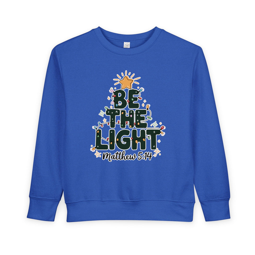 Royal-blue toddler sweatshirt with BE THE LIGHT Christmas tree design and Matthew 5:14 text, featuring durable construction for warmth and comfort.