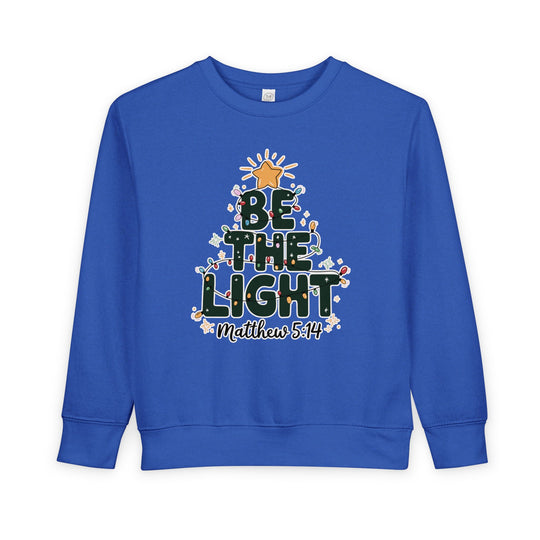 Royal-blue toddler sweatshirt with BE THE LIGHT Christmas tree design and Matthew 5:14 text, featuring durable construction for warmth and comfort.