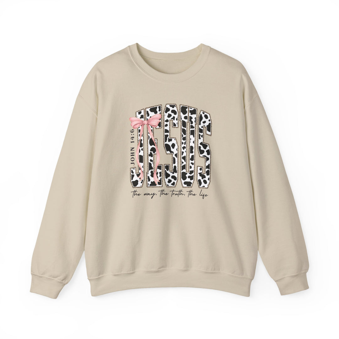 John 14:6 Crew: Beige crewneck sweatshirt featuring JESUS with cow-print letters and pink bow, scripture reference, and cursive phrase below. Comfortable cotton-polyester blend.