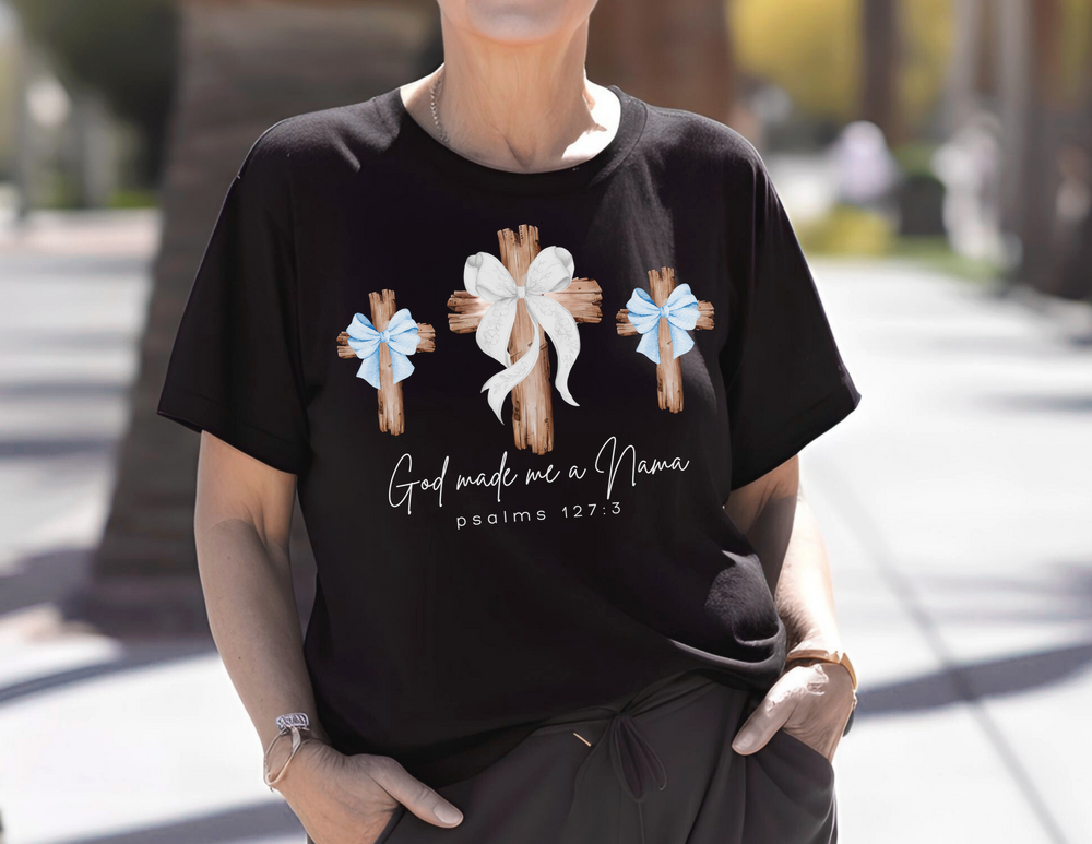 Person wearing God Made Me a Nana tee featuring rustic cross design, accessorized with bracelet and watch, showcasing Comfort Colors' relaxed, durable fit.