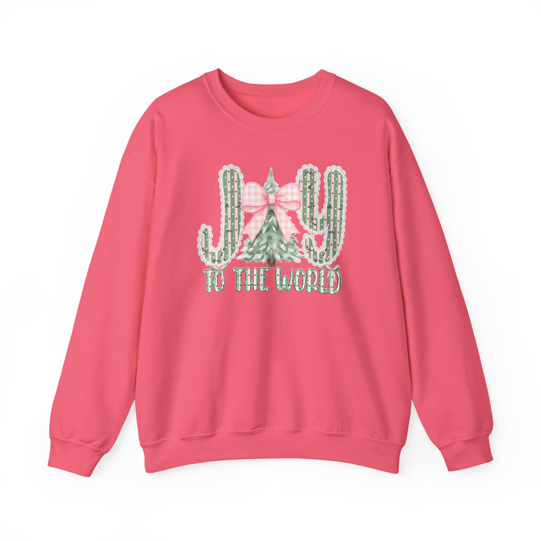 Pink crew-neck sweatshirt with JOY holiday graphic featuring cacti and a Christmas tree, text TO THE WORLD, from Faith Family Designs' Joy to the World Crew collection.