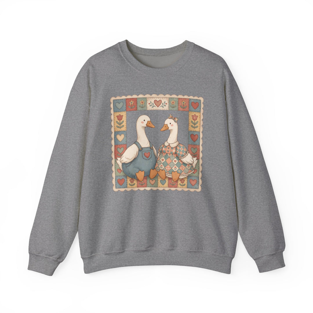 Thrifted Geese Crew: Grey crewneck sweatshirt with folk-art geese illustration, patchwork quilt motif, cozy country-inspired design, made from a comfortable polyester-cotton blend.